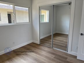 Gardena apartment for rent - a bedroom with mirrored closet doors and a hard wood floor